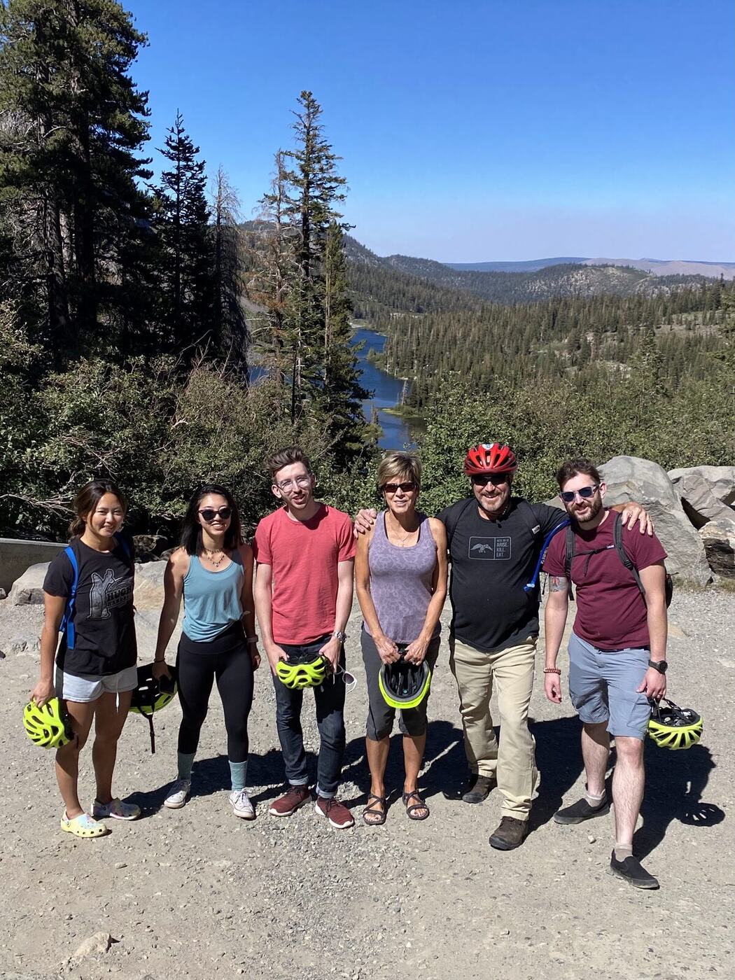 Group with bike helmets posing at forest overlook