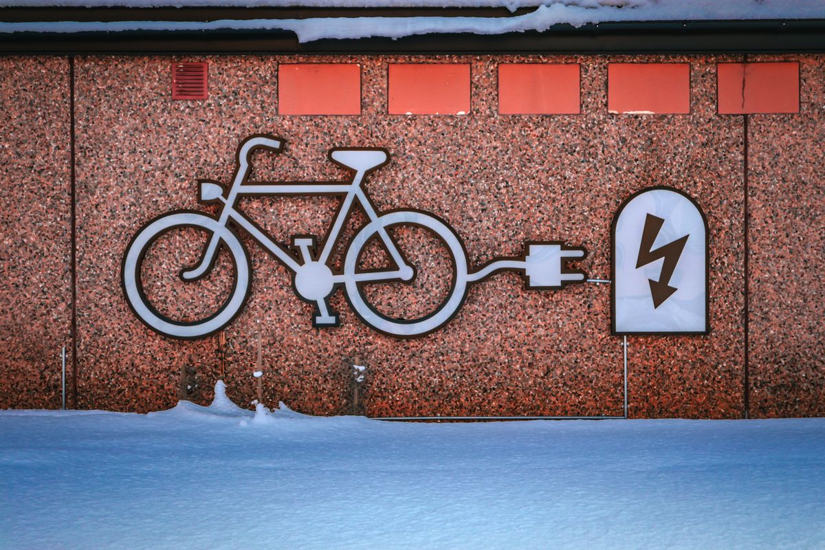Bicycle and charging plug mural painted on a building wall